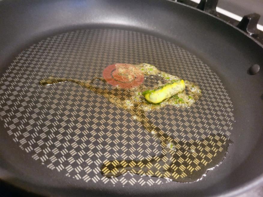 Herb cube sizzling in frying pan