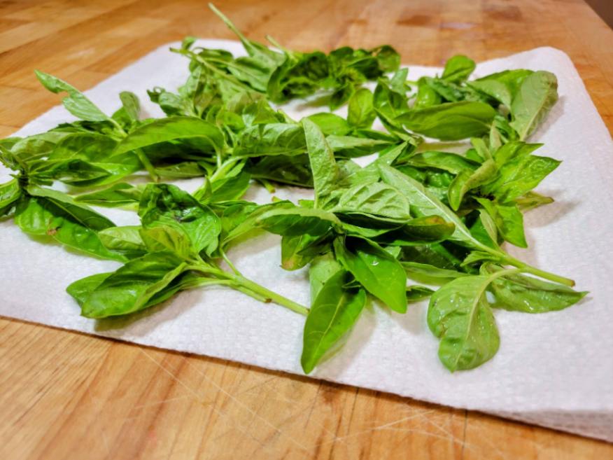 Drying herbs on papers towels on a butcher block counter