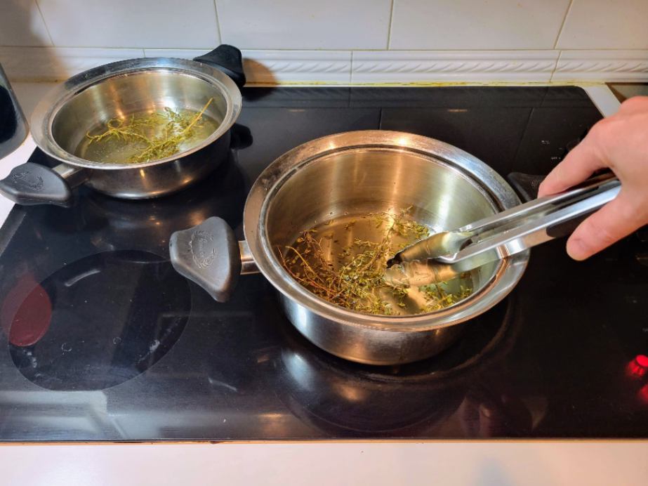 Infusing olive oil with herbs on stove top