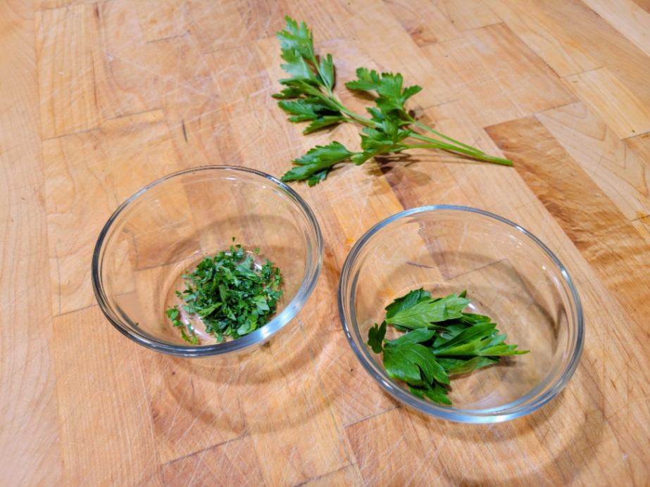 Italian parsley sprig and measures in glass bowls on a butcher block counter